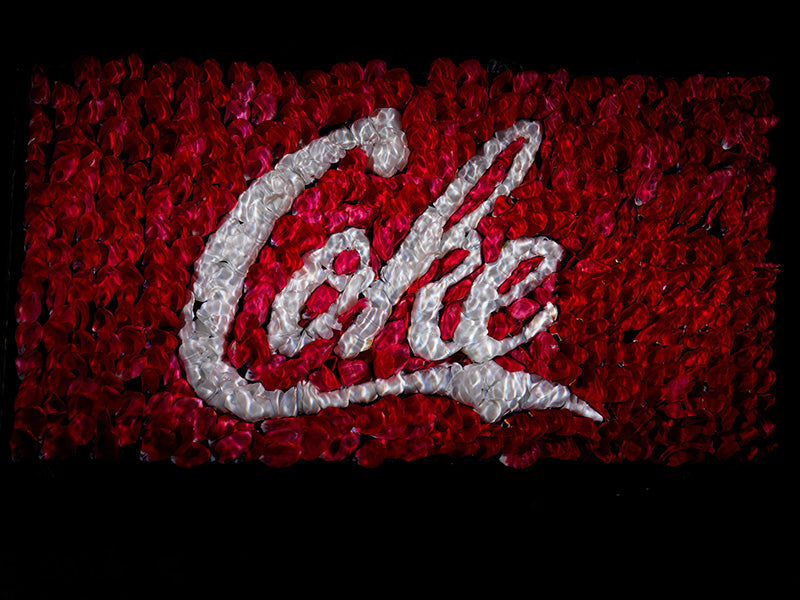 The coke coca cola brand remade in flower petals underwater