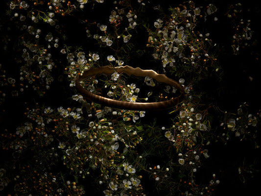 Rippled Poetic Scene of a Gold Halo on Green Leaves with White Blooms ripples of water above