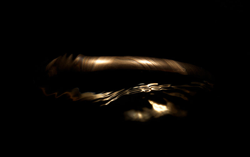 Fluid Gold Halo in Dark Underwater Scene