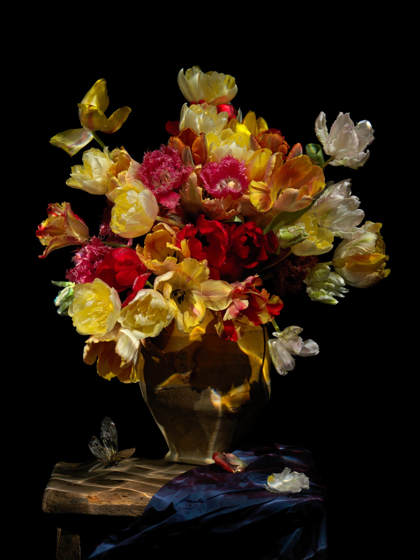 Vanitas floral composition with tulips in a dark vessel